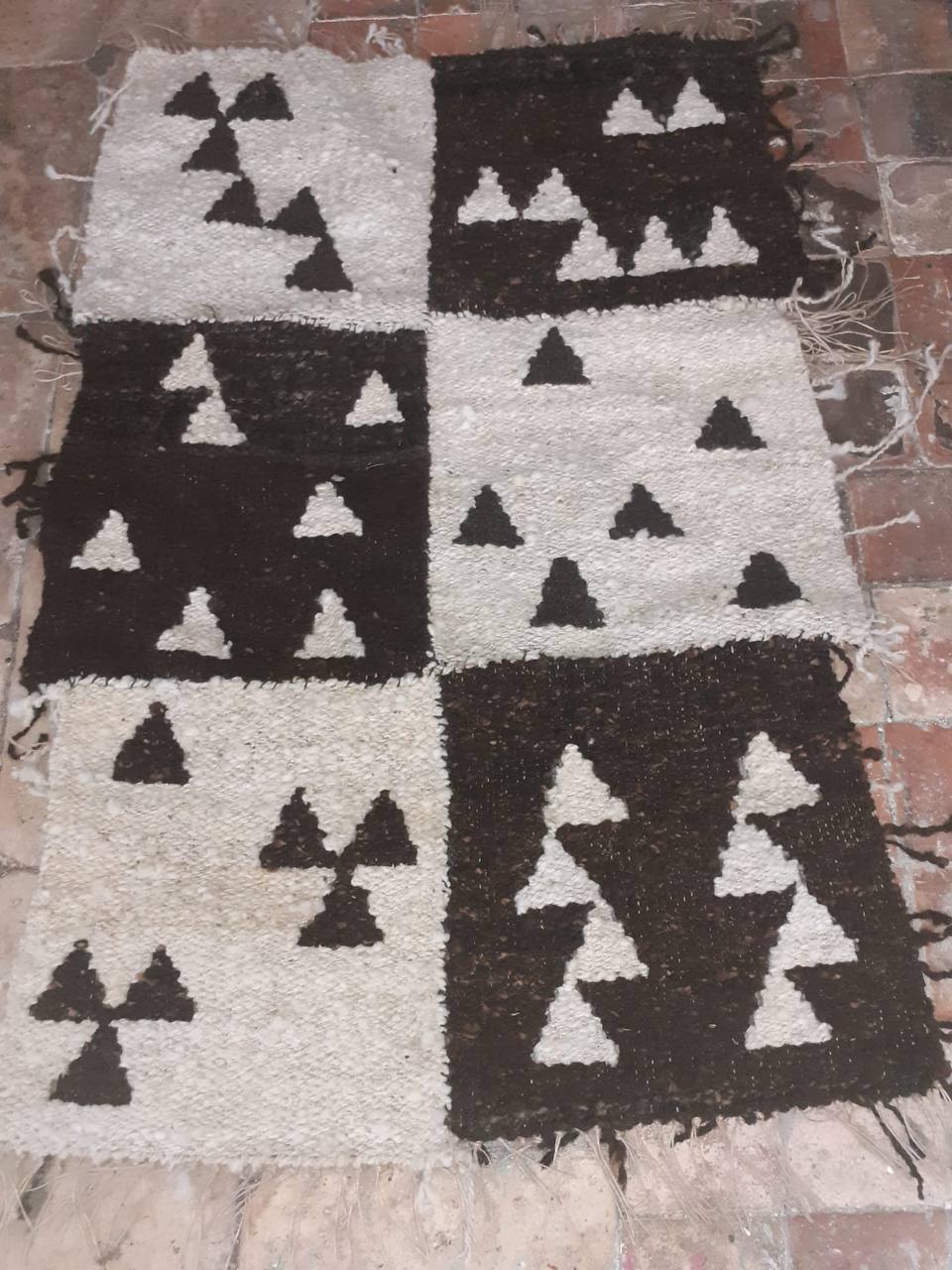 Black and white handwoven rug with geometric tree motifs